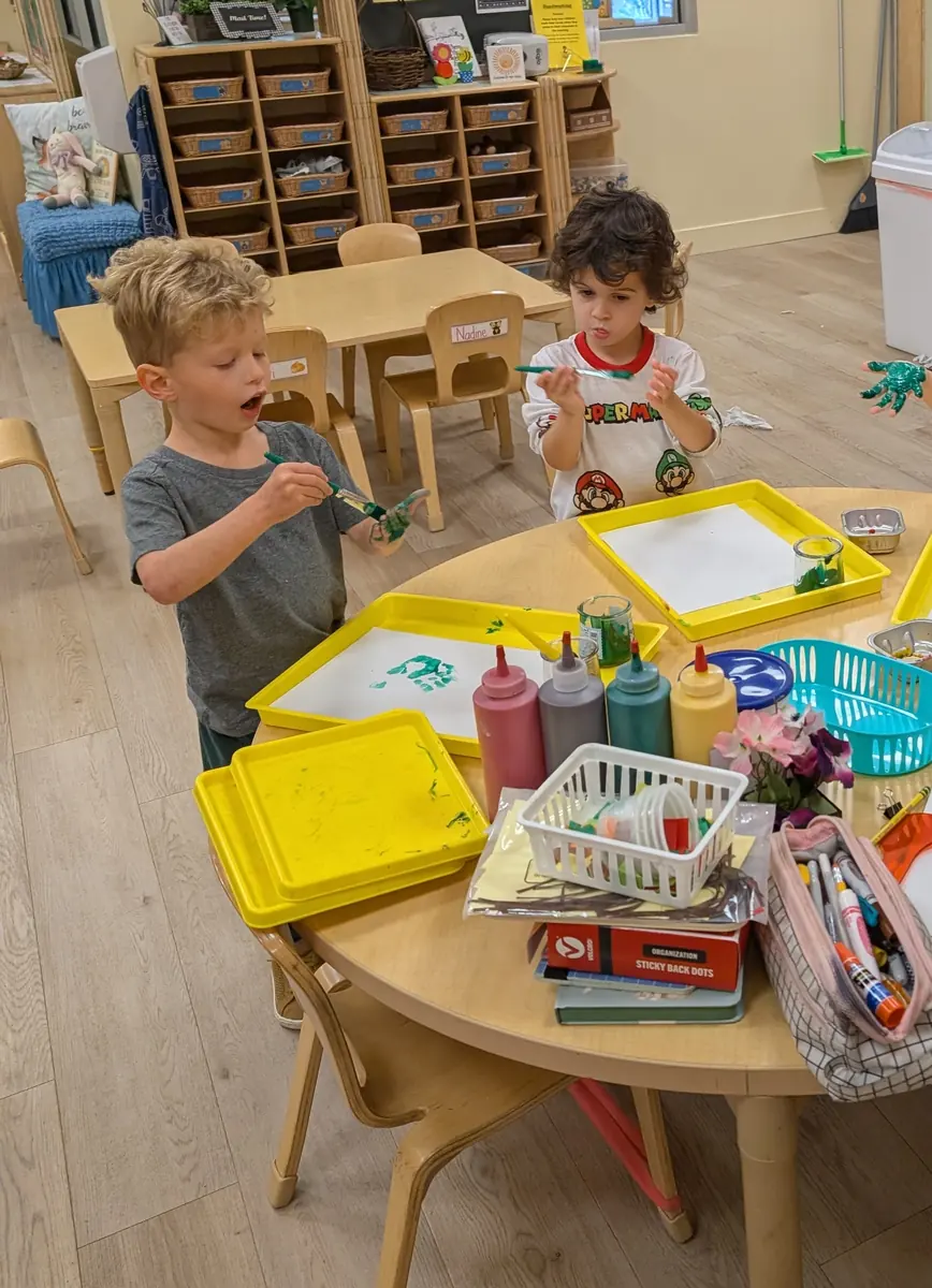 Preschoolers making handprint art together at Blossom Station in Acton, MA