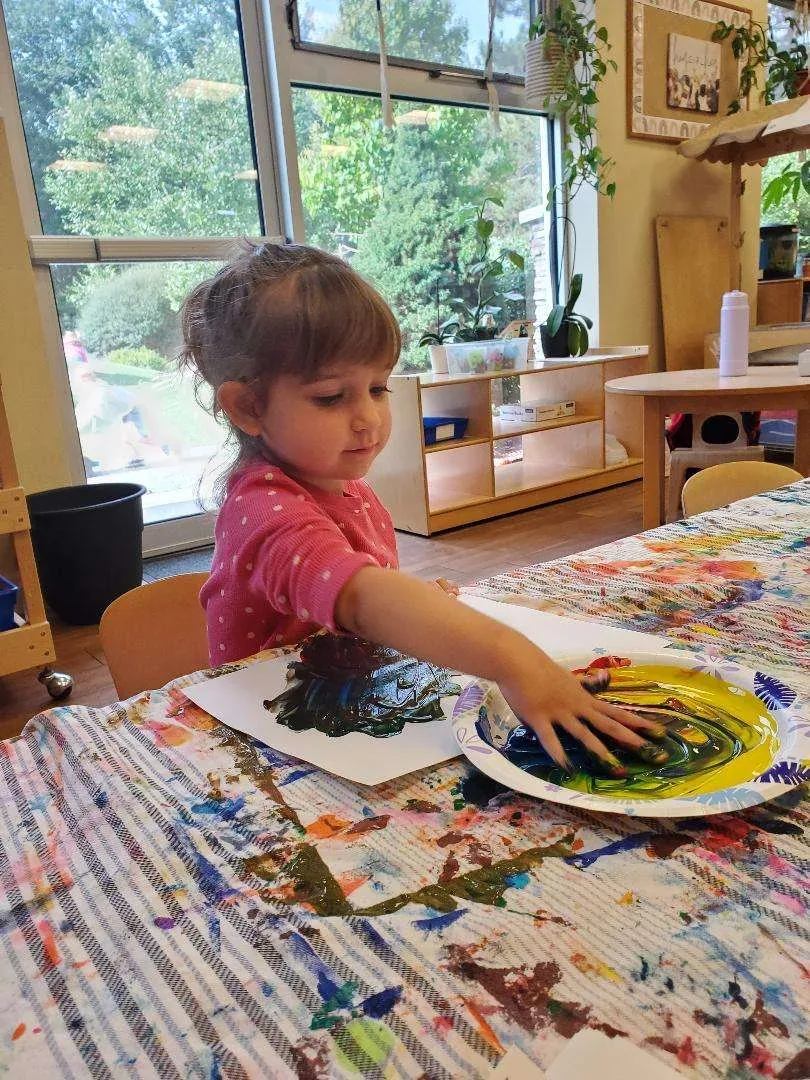 A child creating art in the classroom at Blossom Station in Acton, MA