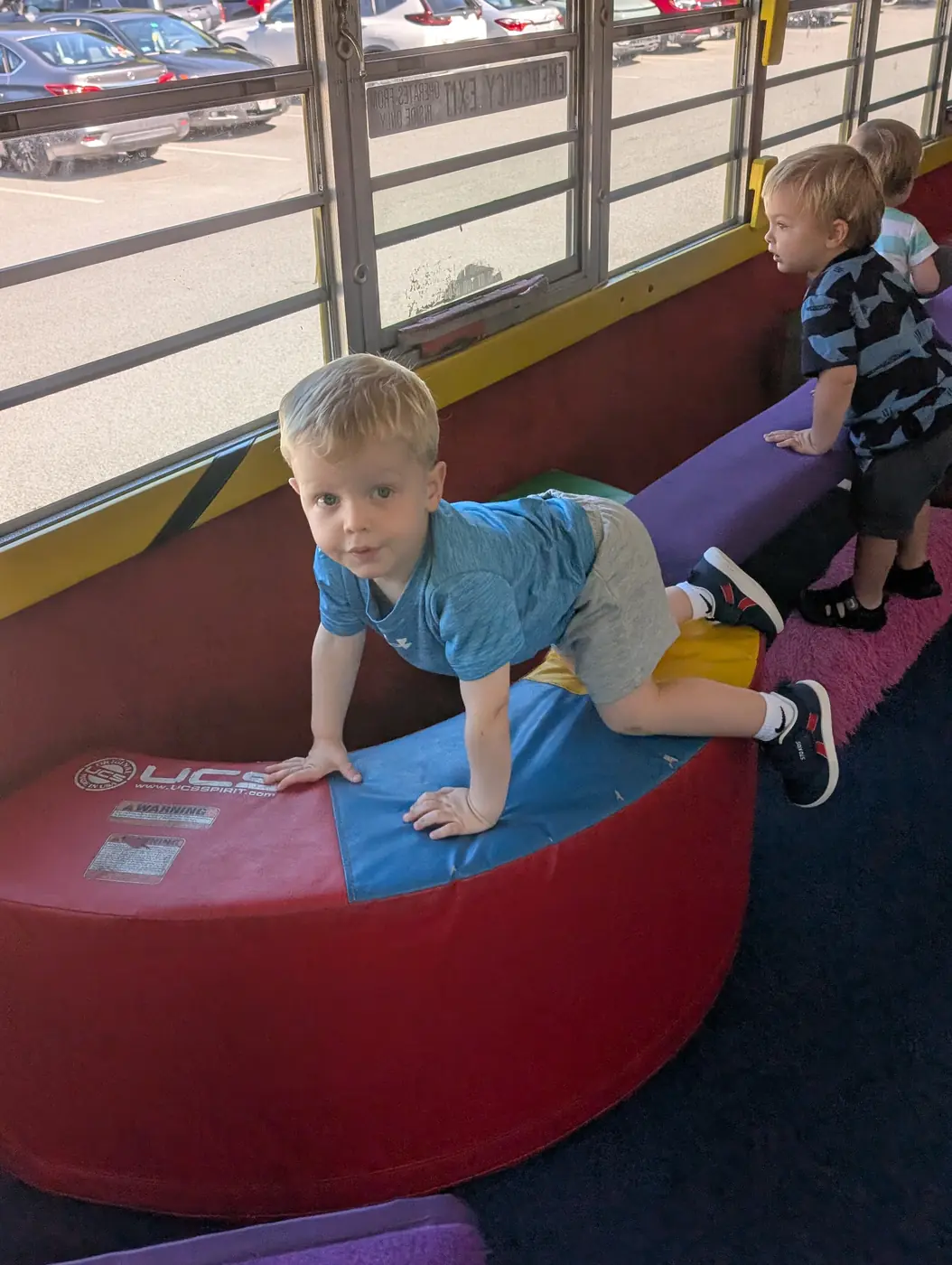 A toddler climbing the soft-play equipment in the play bus at Blossom Station