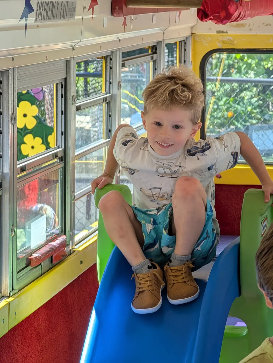 A child going down the play-bus slide at Blossom Station