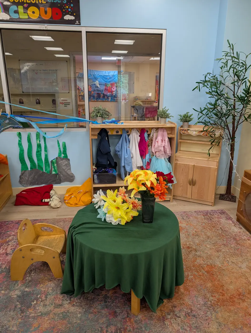 A dramatic-play area with a play kitchen and dress-up corner at Blossom Station